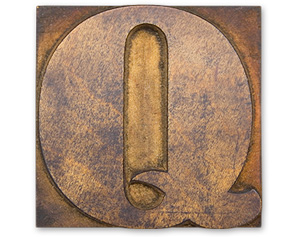 Antique wood cut block of the letter Q