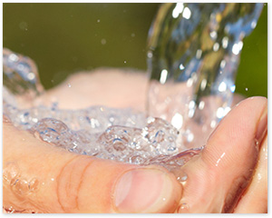 Second third of picture of water pouring into two cupped hands