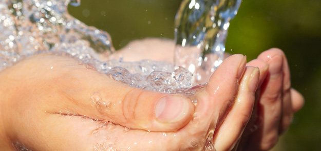 Picture of water pouring into two cupped hands